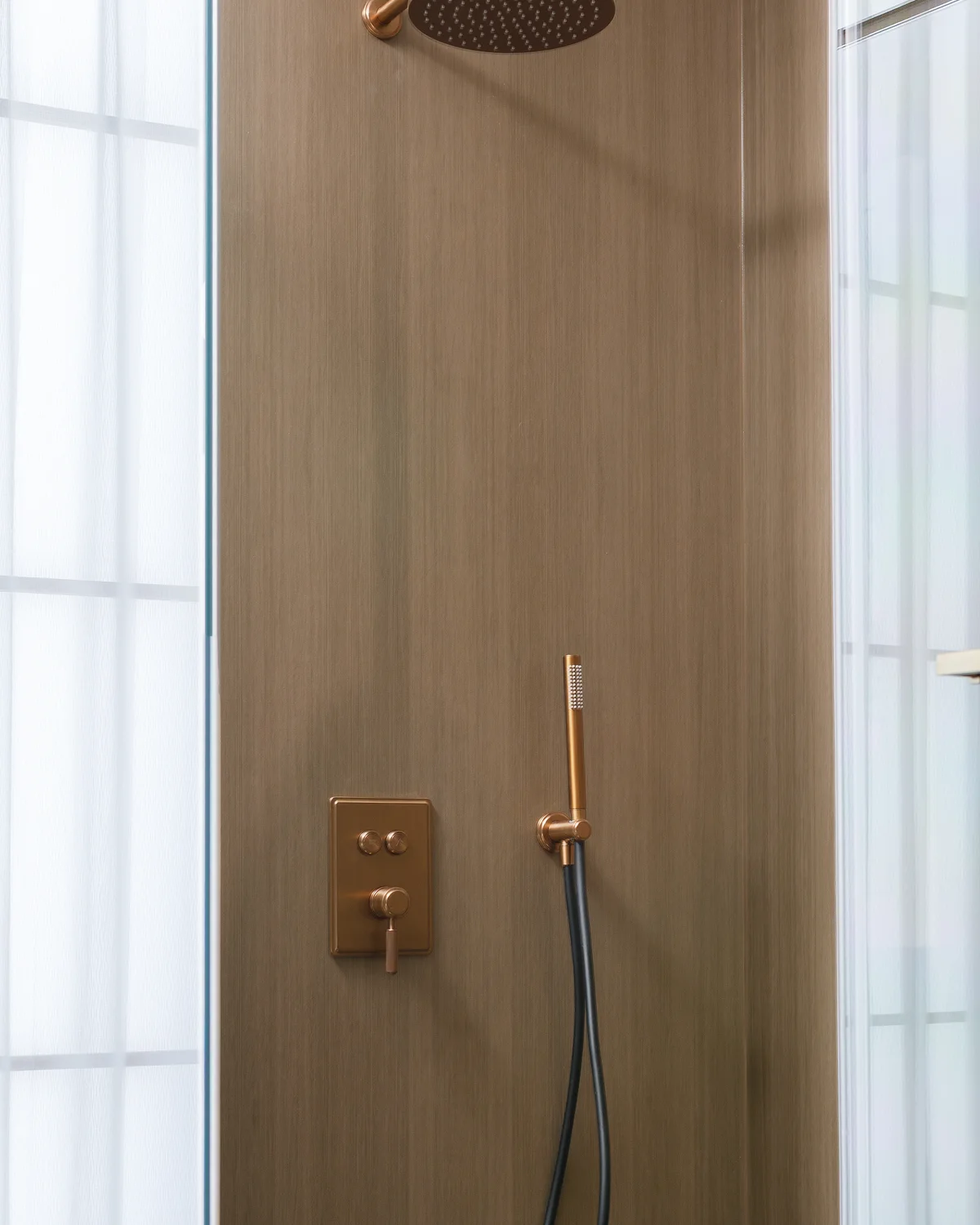 Brass shower system in a complete bathroom setting